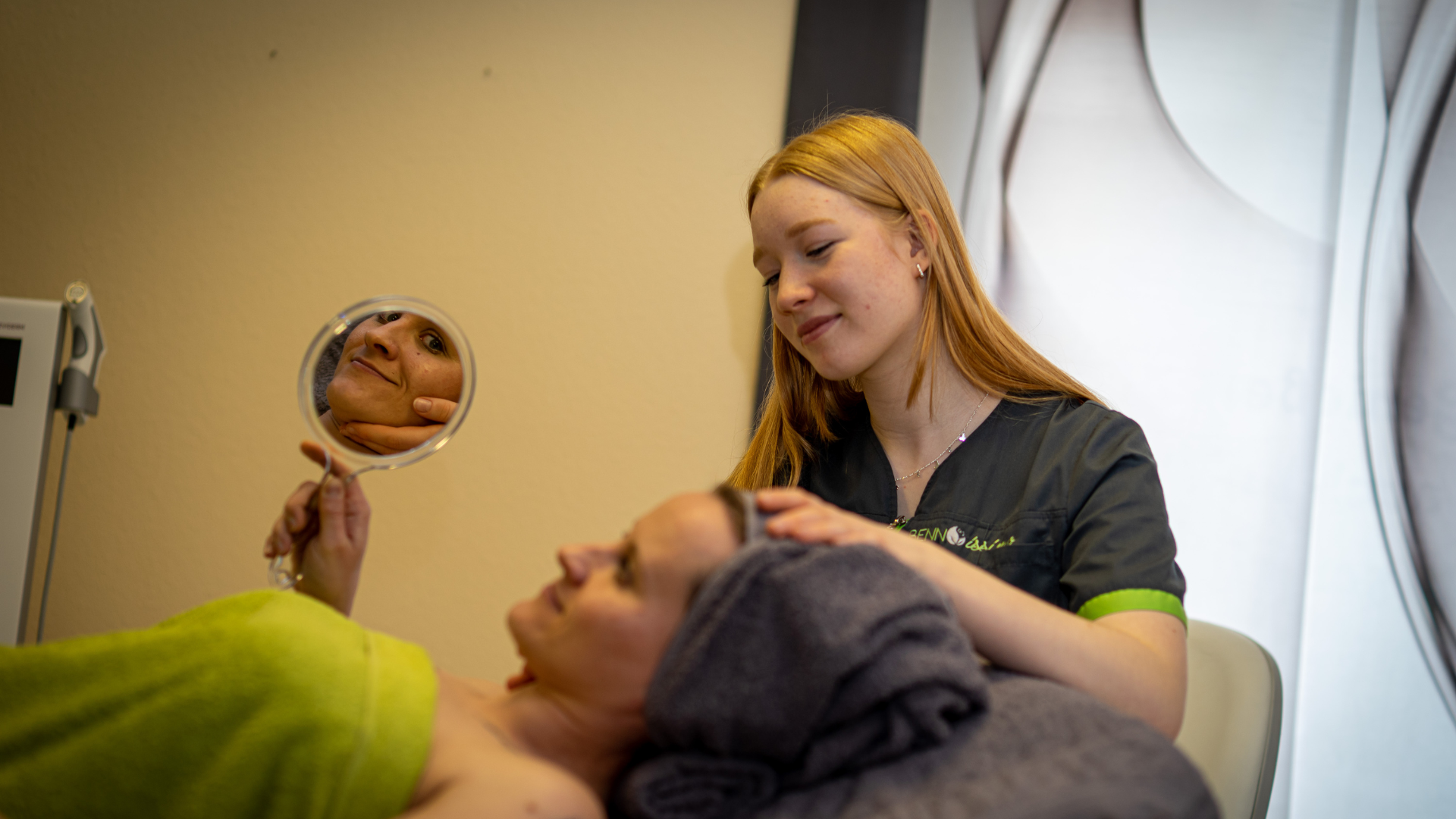 Die Kundin schaut sich zufrieden nach der Behandlung im Spiegel an